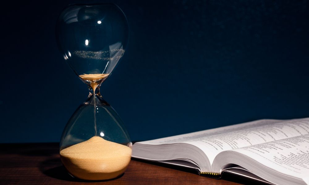 hourglass almost empty next to book, ending your mystery