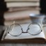 stack of books with reading glasses on top; the difference between contemporary fiction and literary fiction