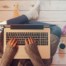 woman sitting on floor typing on a laptop; 9 steps to write a book