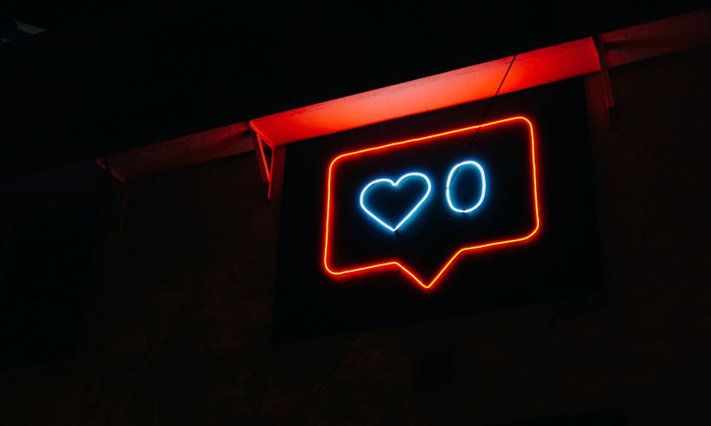 neon sign of Instagram "like" image of heart and 0; A Writer's Guide to Crafting the Perfect Instagram Bio