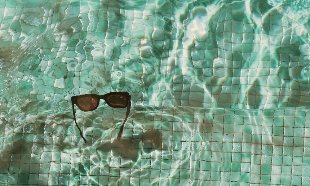 sunglasses floating in pool; summer fun for writers