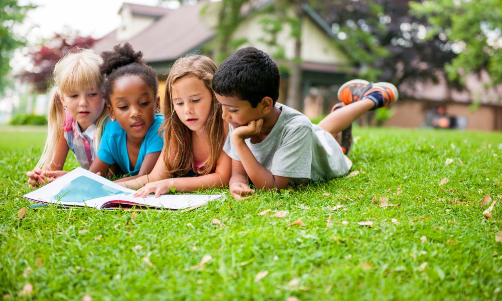 kids reading in park together; book-related activities for kids