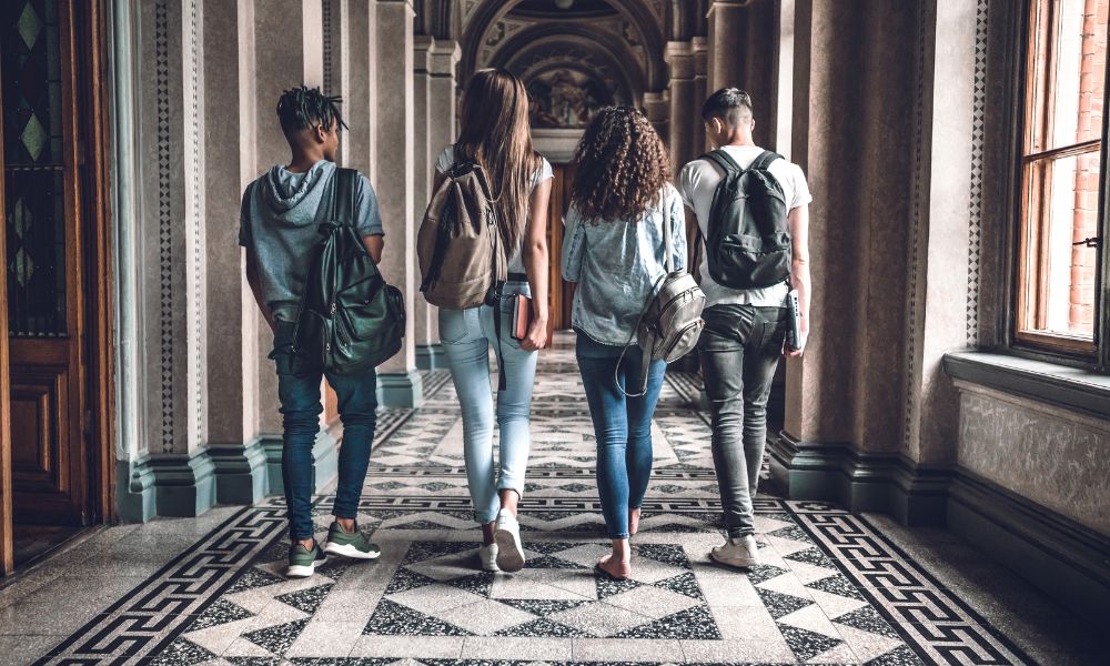 four college students walking a hallway on campus
